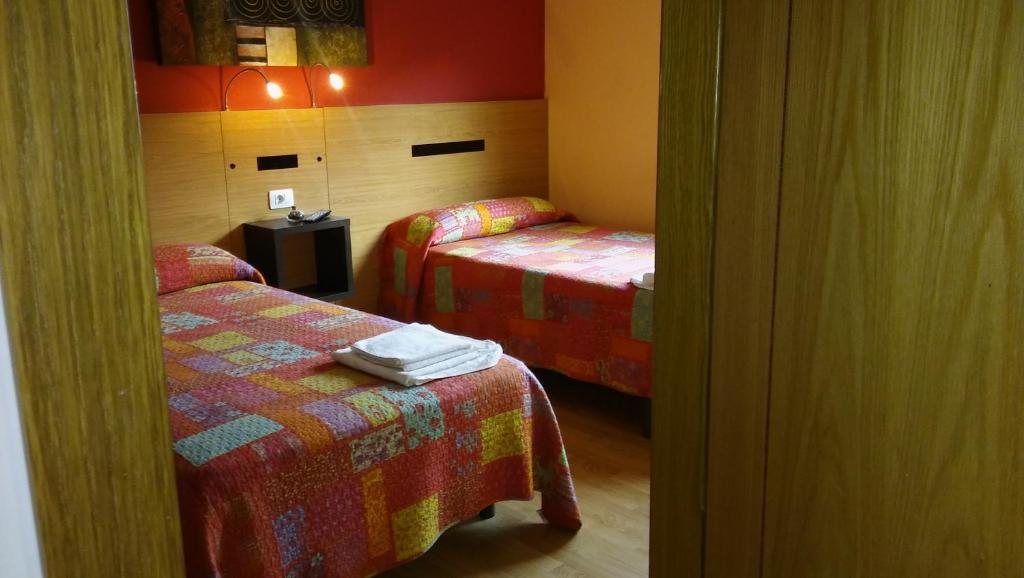 特里亚卡斯特拉Hostal-Meson Vilasante的一间设有两张床和一张桌子的房间