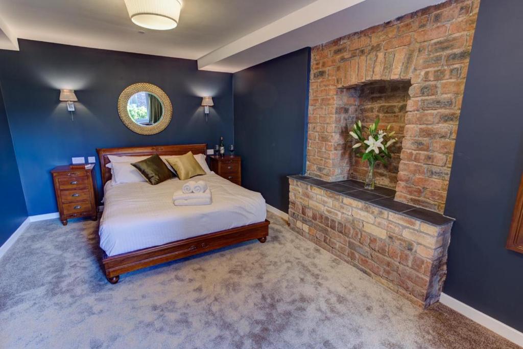 斯特灵Friars Wynd Hotel的一间卧室配有一张床和一个砖砌壁炉