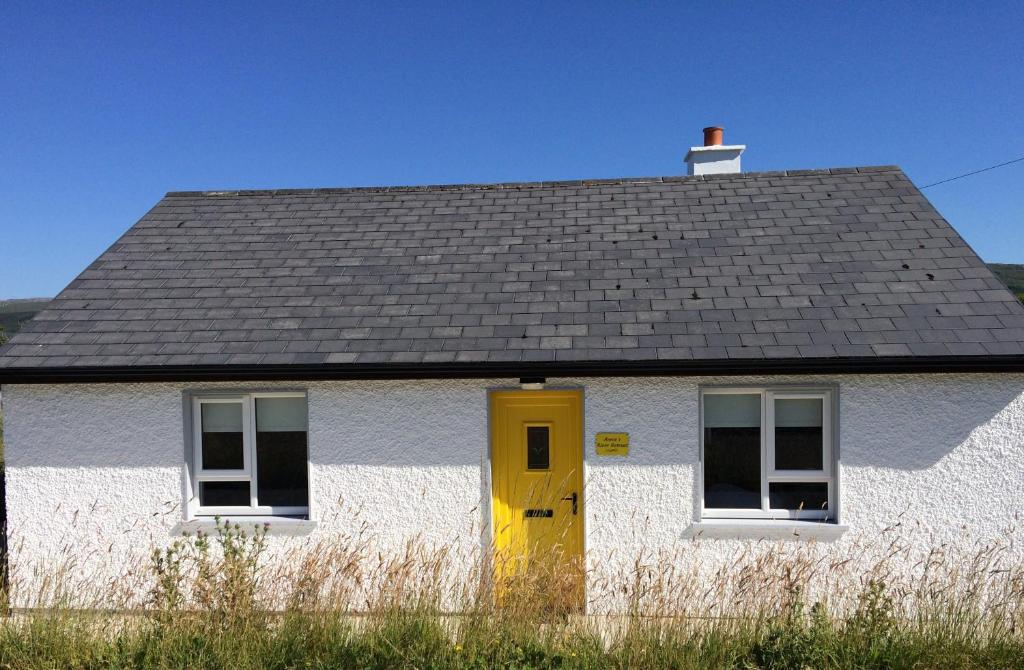 DoocharyAnnie's River Retreat的白色的房子,有黄色的门和屋顶