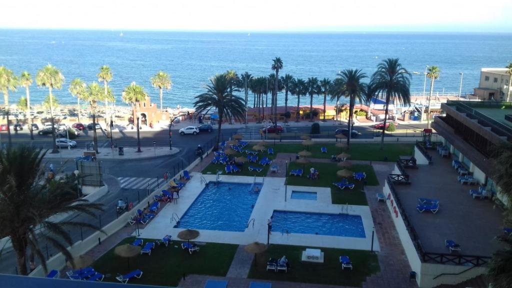 贝纳尔马德纳Estudio playa Benalmadena的享有带游泳池和海洋的度假村的空中景致