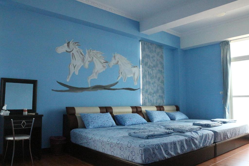 马公驫風民宿 Equuleus Homestay的蓝色的卧室,墙上有一张马床