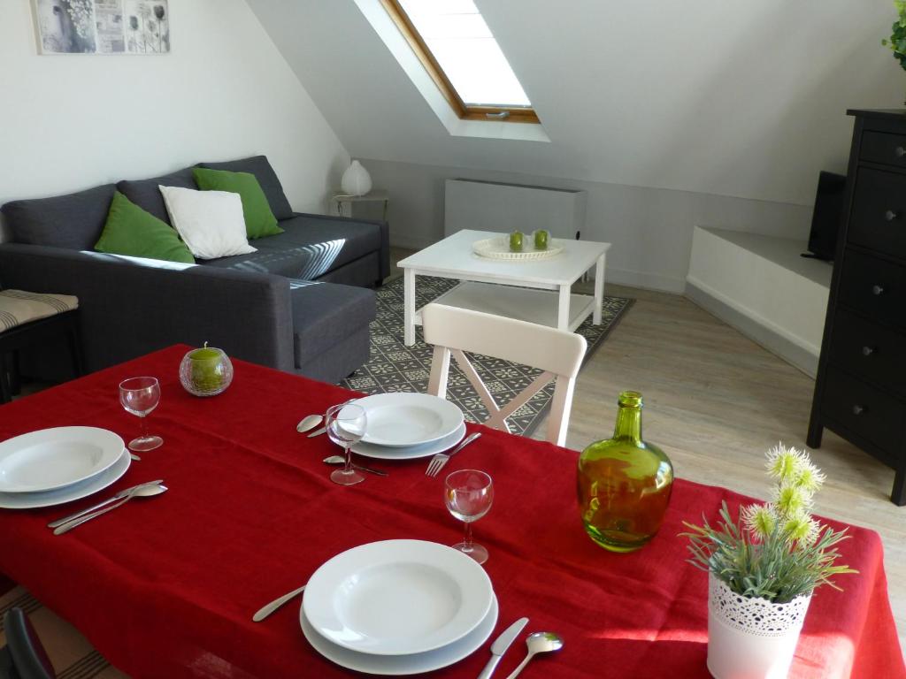 布里夫拉盖亚尔德Les Doctrinaires的客厅配有一张桌子和红色桌布