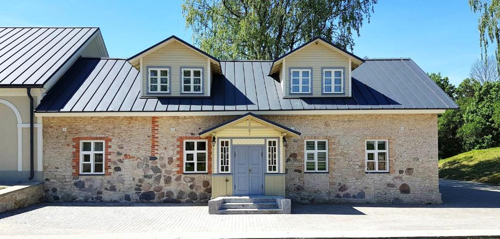 珀尔察马Pajusi Mõisa Külalistemaja的一座带金属屋顶的大型砖屋