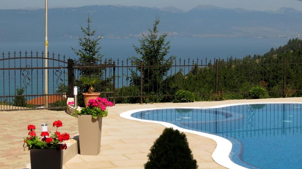 奥赫里德Villa Angelos的一座鲜花盛开的游泳池,享有水景