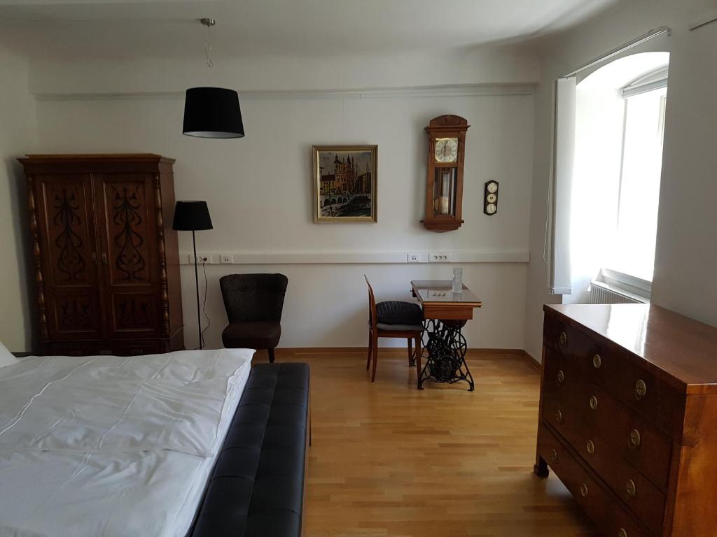 卢布尔雅那SIPPO Apartments的一间卧室配有一张床、一张桌子和闹钟