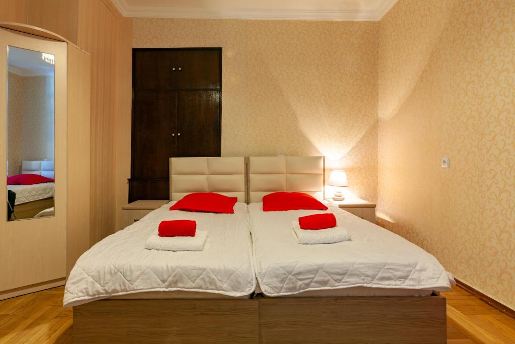 第比利斯Guest House Keria的一间卧室配有一张带红色枕头的大床