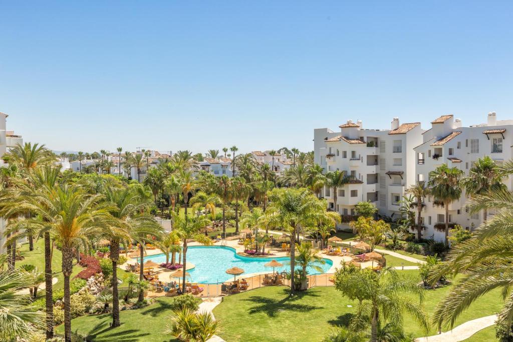 EsteponaSea & mountain view penthouse的享有度假村的空中景致,设有游泳池和棕榈树