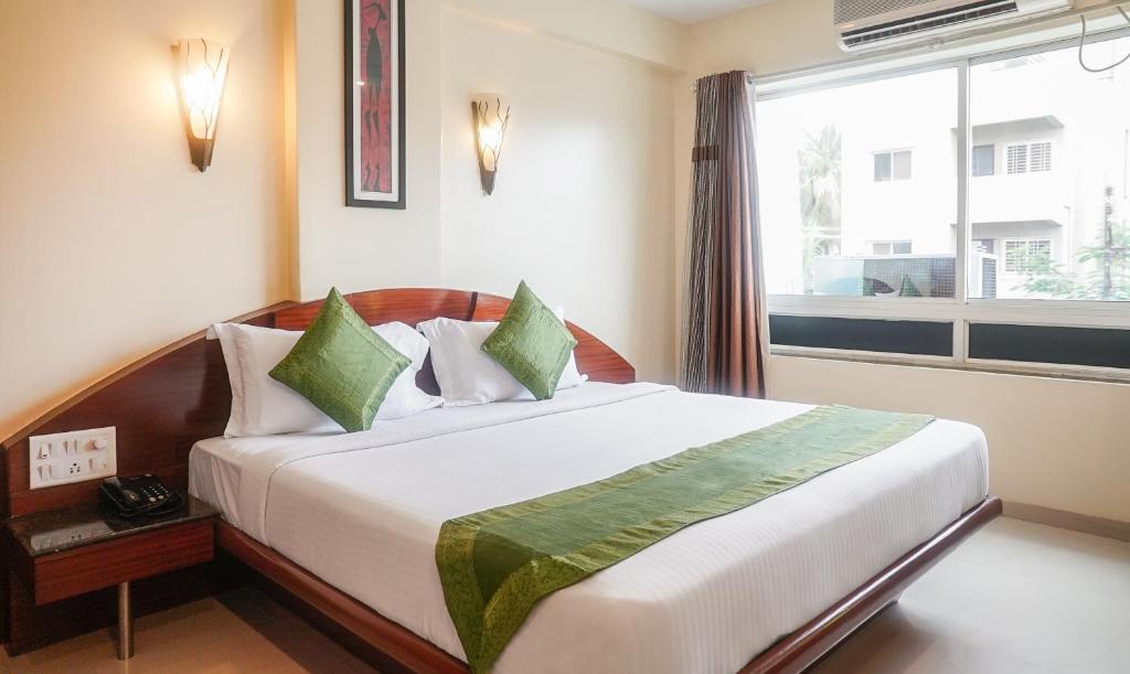浦那Treebo Trend Brahma Regency的一间卧室设有一张大床和窗户
