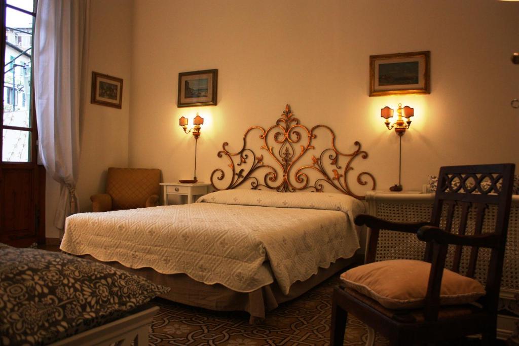 佛罗伦萨Rooms by Anna的一间卧室配有一张床、两盏灯和一把椅子