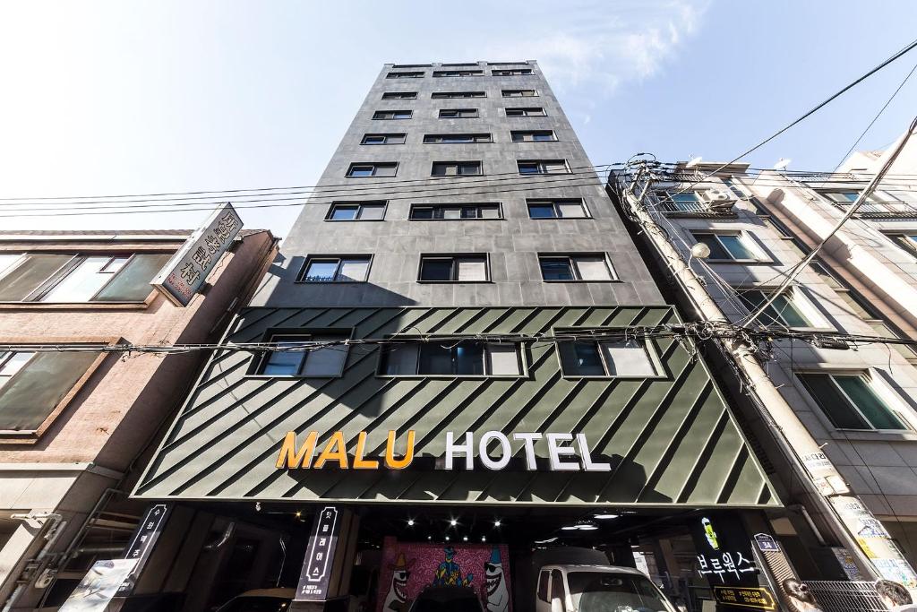 水原市Malu Hotel Suwon的一座大型建筑,上面有宏伟的酒店标志