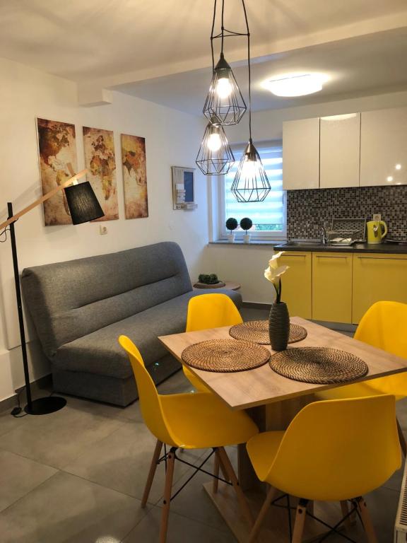 奥西耶克Apartment Park的厨房以及带桌子和黄色椅子的客厅。