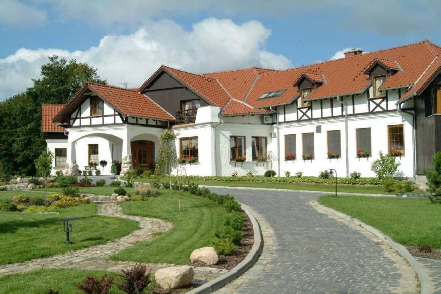 TrzebiatówDworek nad Regą的前面有一条小径的大白色房子