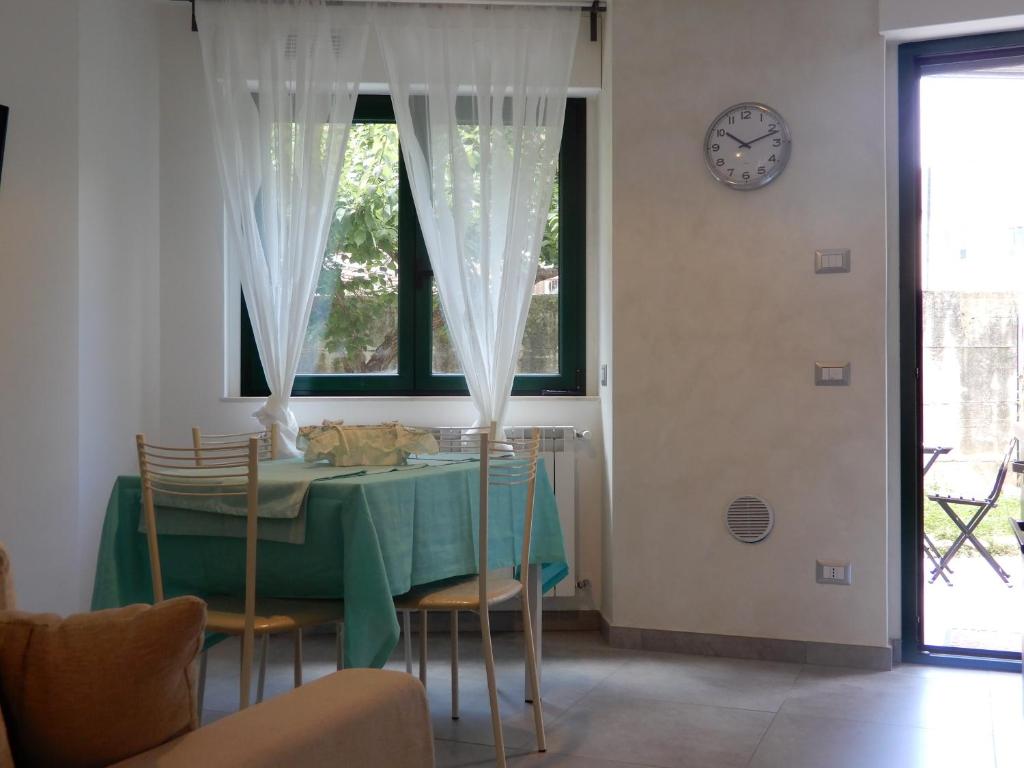 坎波巴索casa vacanze luciano&son的一间带桌椅和时钟的用餐室