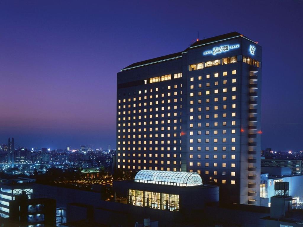 东京东京东方21世纪酒店的一座建筑物,上面有夜间标志