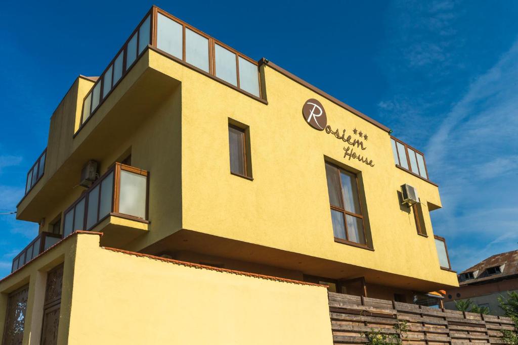 泰基尔吉奥尔Rosiem House的黄色的建筑,旁边标有标志