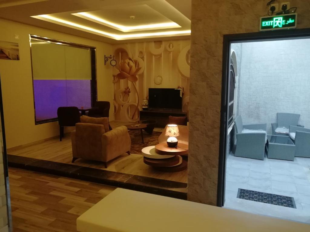 艾卜哈Al Worod Al Thahabia Chalets的带沙发和投影屏幕的客厅