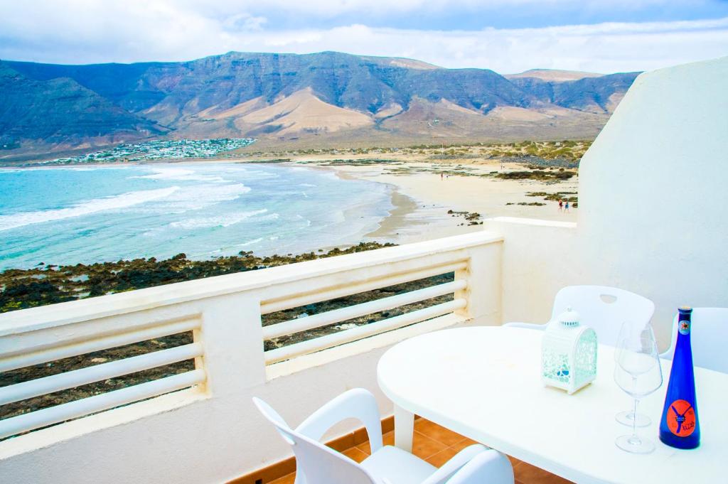 法马拉Seaview Risco de Famara 1的海滩阳台的白色桌椅