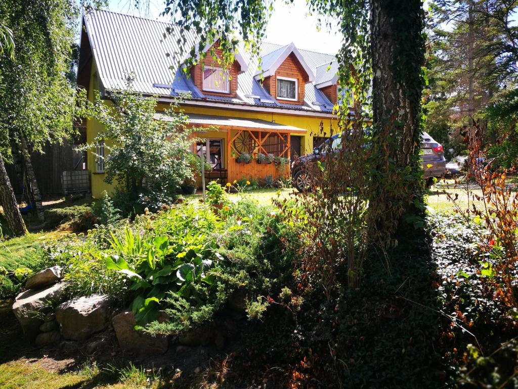 WiżajnyAgrowczasy u Mirusi的黄色的房子,前面有一个花园