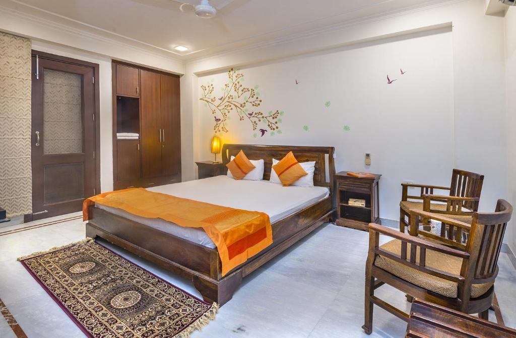 新德里生活树住宿加早餐酒店的一间卧室配有一张床和一把椅子