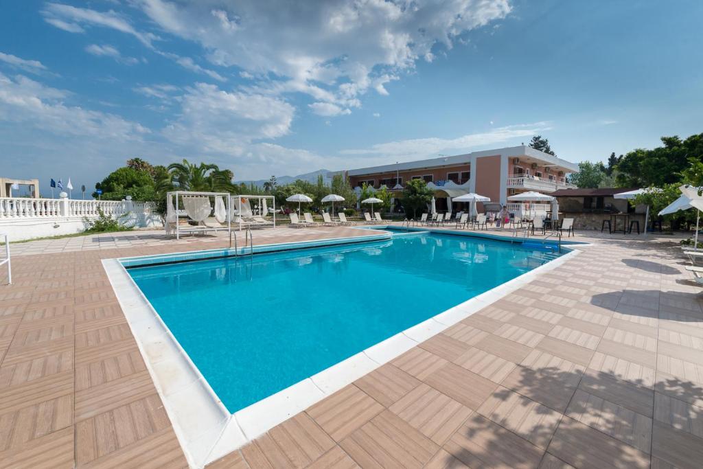 阿尔戈斯托利翁银河酒店的度假村的游泳池,配有椅子和遮阳伞