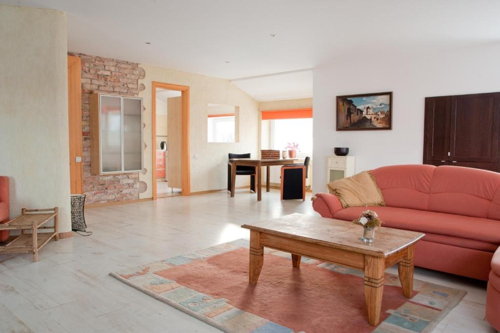 阿利图斯Old Town Apartments的客厅配有红色的沙发和桌子