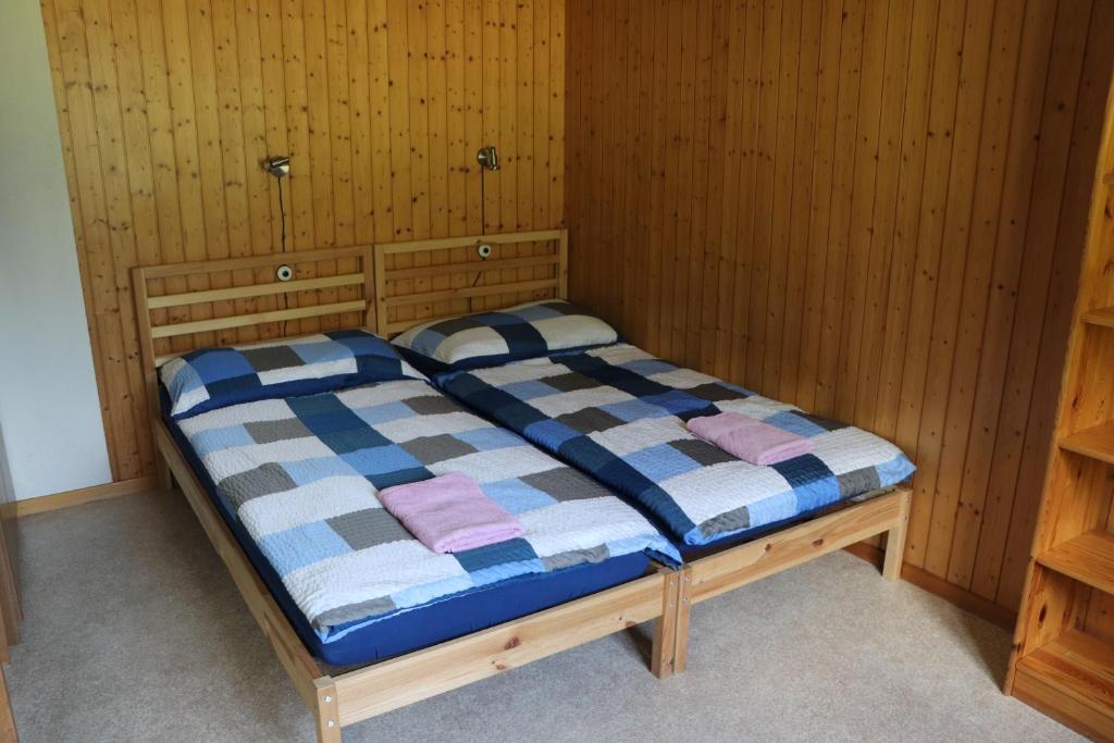 布里恩茨Homestay Brienz的木墙客房的一张床位