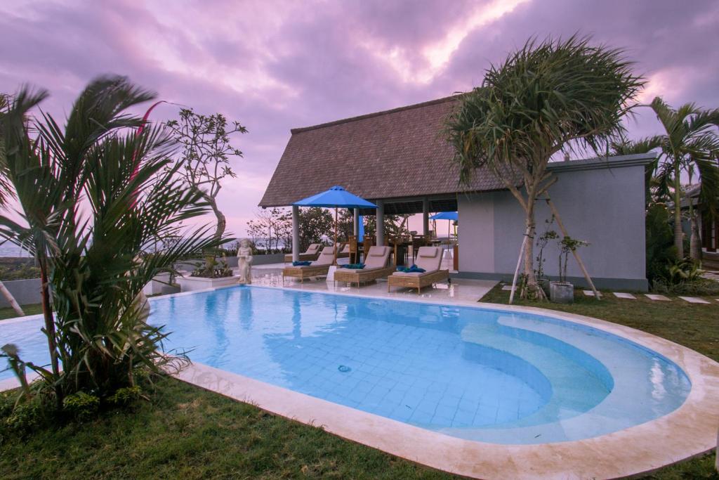 KusambaThe Secret Spot Villas的一个带椅子的游泳池以及一座房子