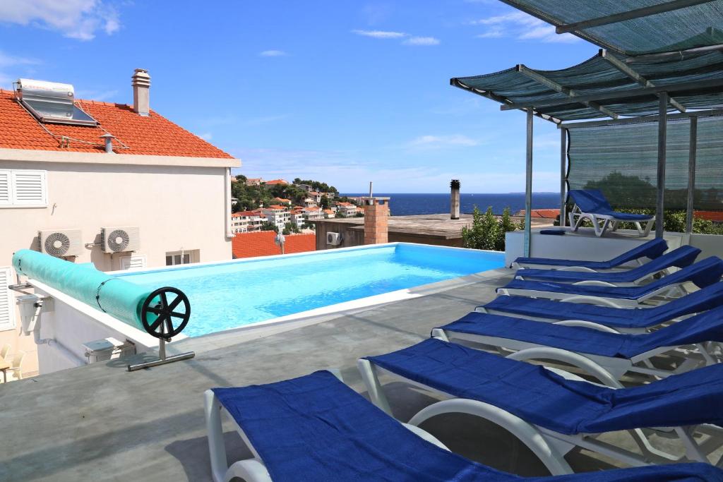 扎瓦拉提卡Villa Korculaholidays的一个带蓝色椅子的游泳池和一个游泳池