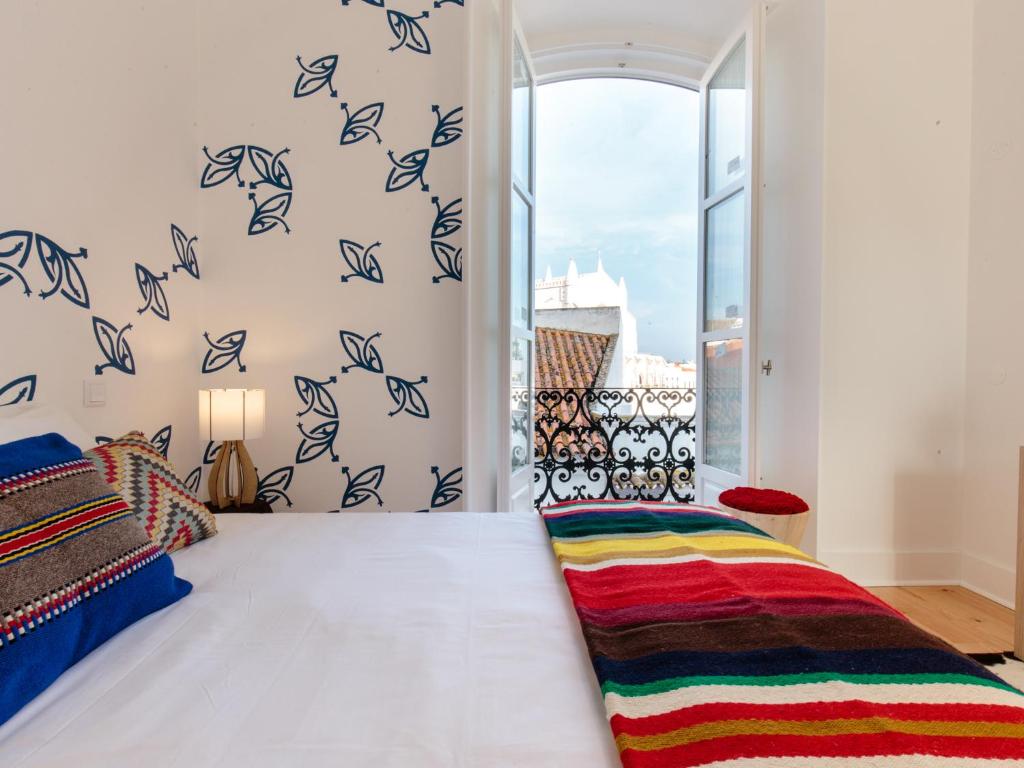 埃武拉Heaven Inn Suites & Terrace的一间卧室设有一张床,墙上有窗户,有鸟儿