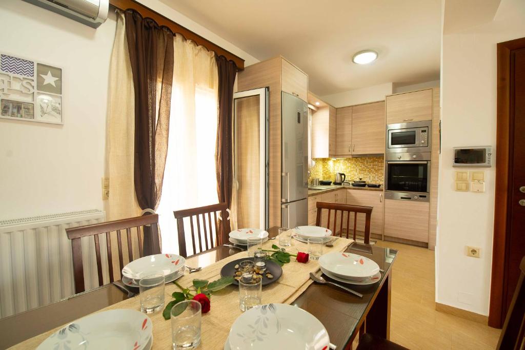 MoíraiStefanos Family Apartments的厨房配有带餐盘和碗的餐桌