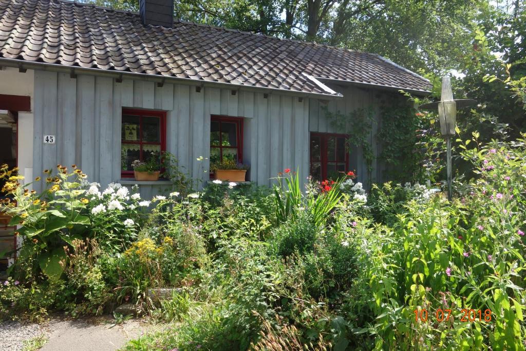 罗埃特根Ferienhaus Quick's Cottage的鲜花屋前的花园