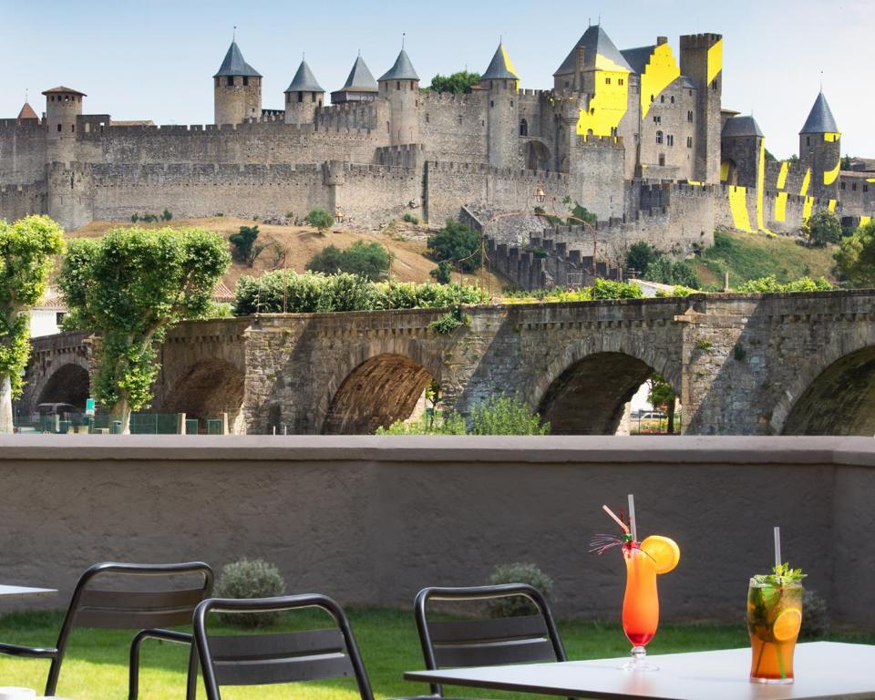 卡尔卡松SOWELL HOTELS Les Chevaliers的城堡景客房 - 带桌椅