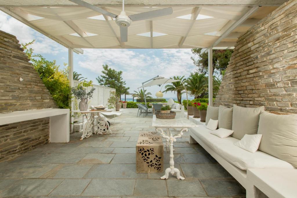 佩科霍里Villa Aggistri Pefkohori Halkidiki的一个带白色沙发和砖墙的庭院