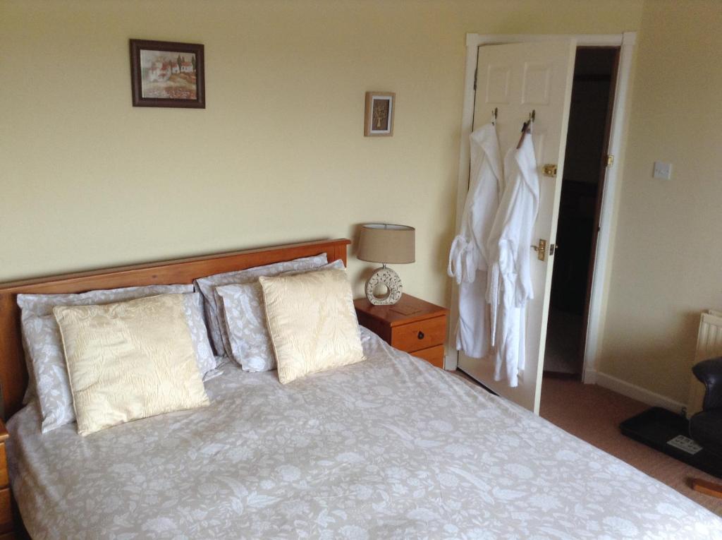 梅伊The Hawthorns B & B的一间卧室配有一张带枕头的床和一个衣柜