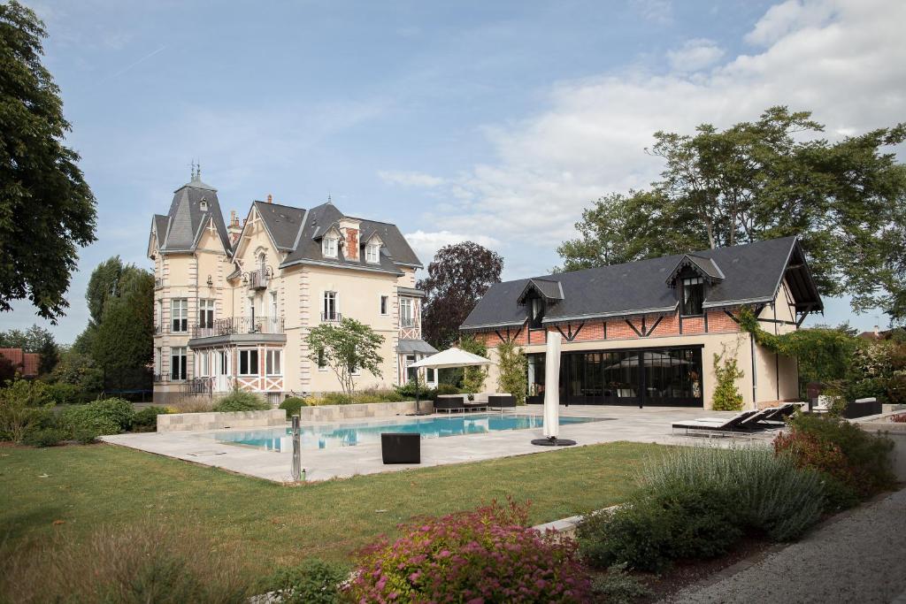 伊芙尔莱韦克Manoir des Logis的一座大房子,在院子里设有游泳池