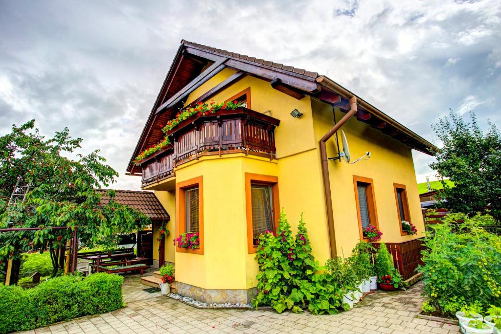 利普托斯基米库拉斯Penzión Janega的黄色房子,设有阳台和鲜花
