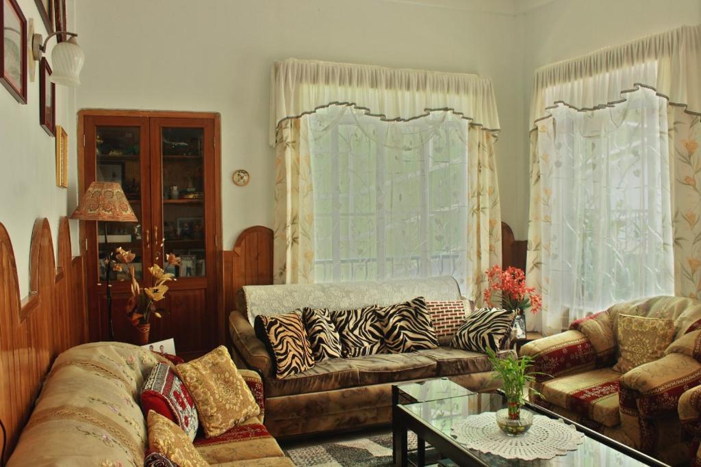 西隆Latei Ville Inn的客厅配有沙发和桌子