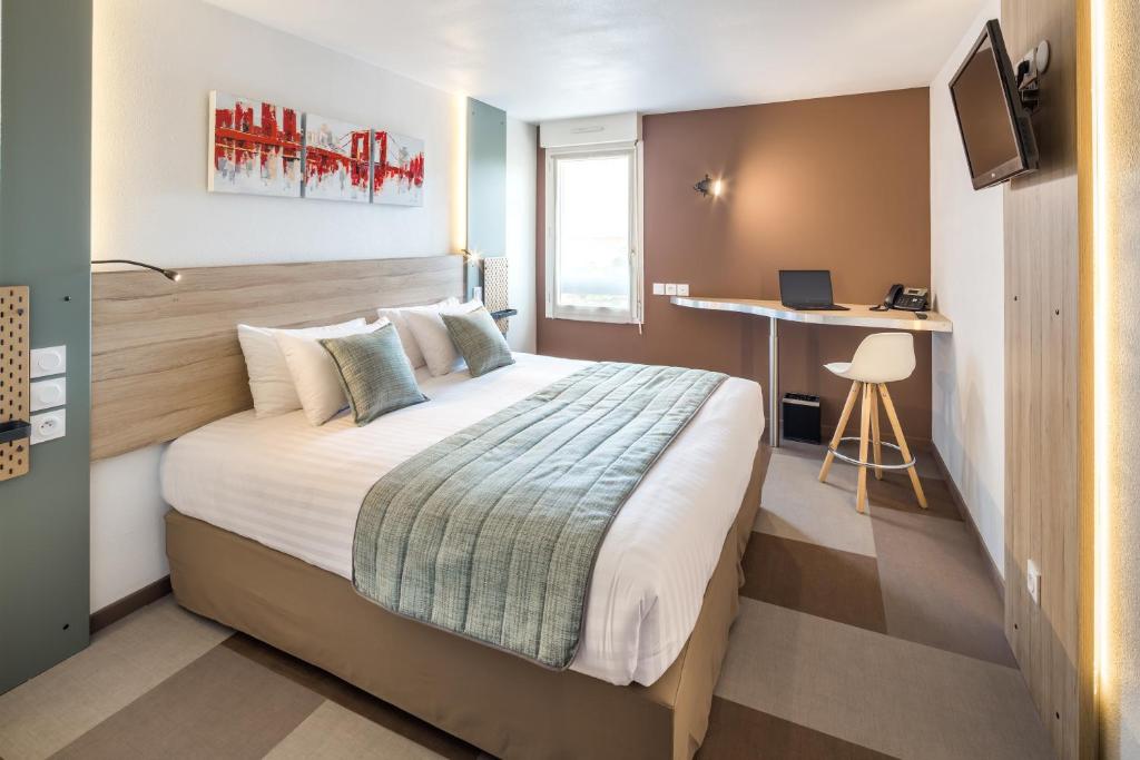 塞雷斯卡斯特Carré Pau Airport Hôtel的配有一张床和一张书桌的酒店客房