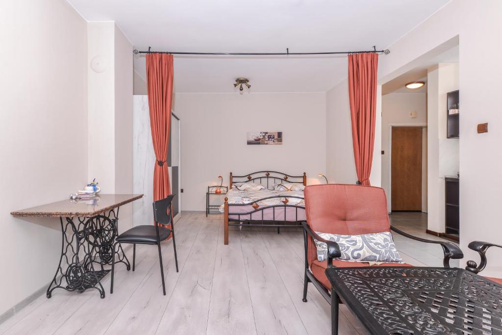 索非亚Visit Sofia | Macedonia Square Central Apartment的客厅配有床和桌椅
