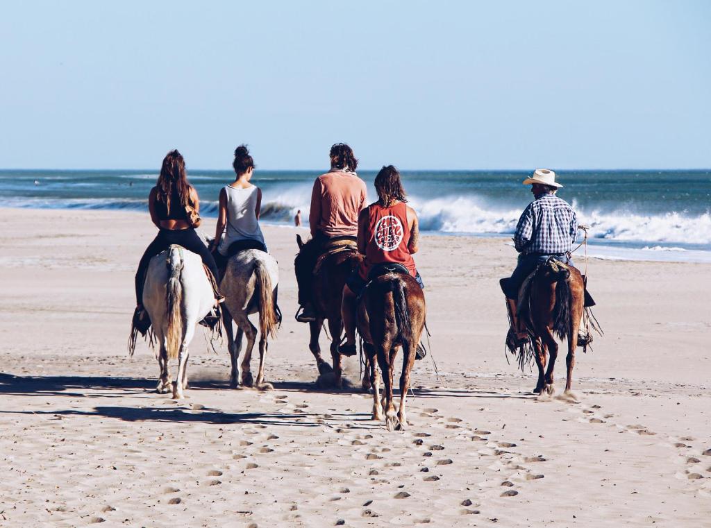 波波约Casitas Pacific的一群人在海滩上骑马