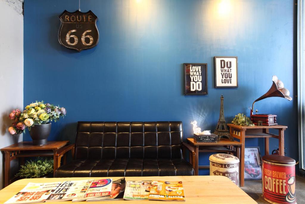 永康图森文旅 Tourism Inn的客厅设有真皮沙发和蓝色的墙壁