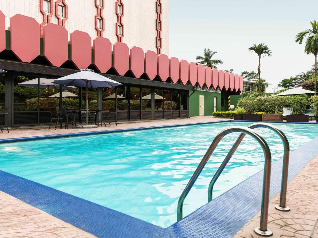 杜阿拉宜必思杜阿拉酒店的一个带遮阳伞的酒店游泳池