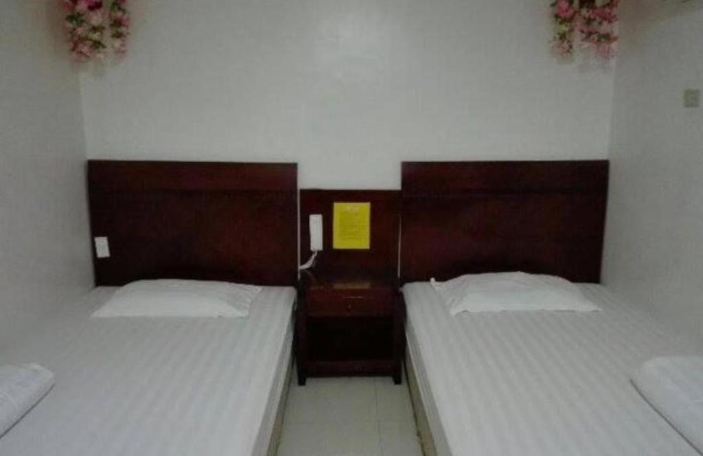 卡利博Asia Novo Boutique Hotel - Kalibo的小客房内的两张床,配有两张sidx sidx单人床