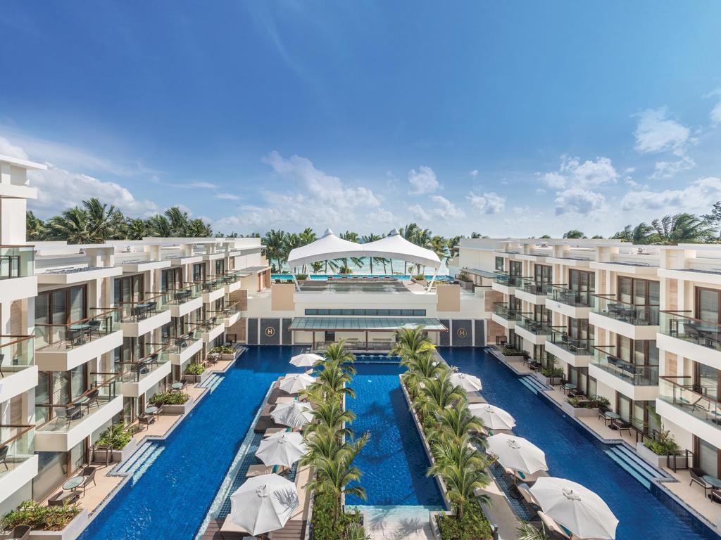 长滩岛赫纳恩棕榈滩度假酒店的享有带游泳池和遮阳伞的度假村的空中景致