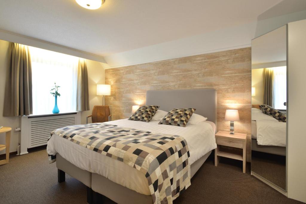斯莱纳肯斯伦纳肯住宿酒店的一间卧室设有一张大床和两个窗户。