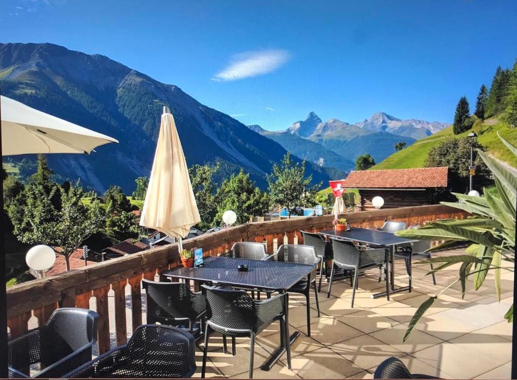 维森索妮哈德酒店加餐厅的庭院配有桌椅,背景为山脉