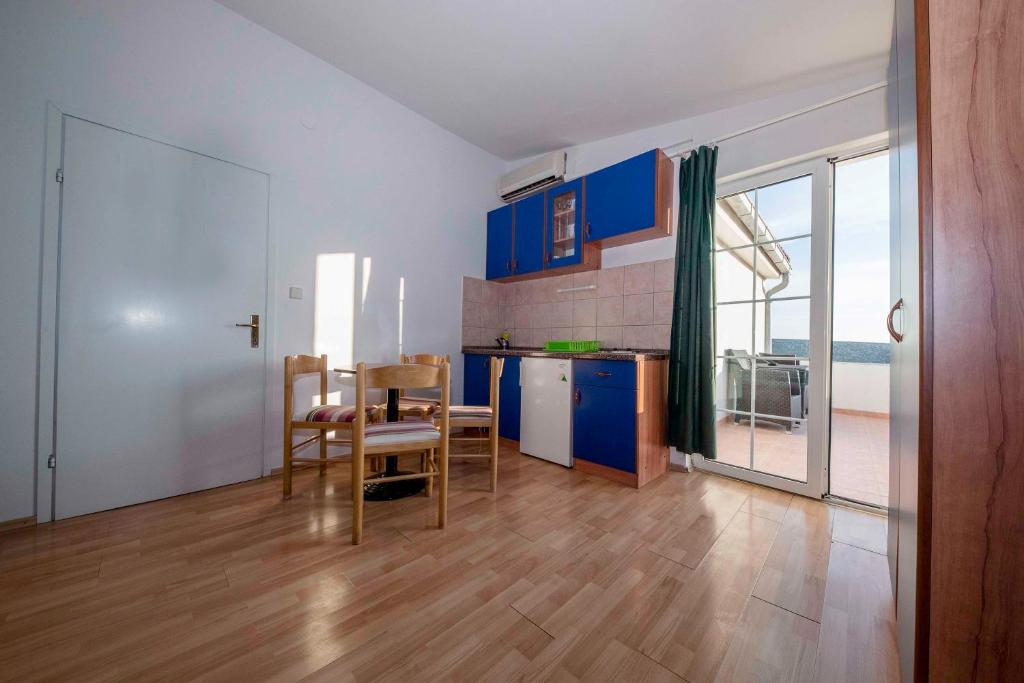 科兰Guesthouse Šime的厨房配有蓝色橱柜和桌椅