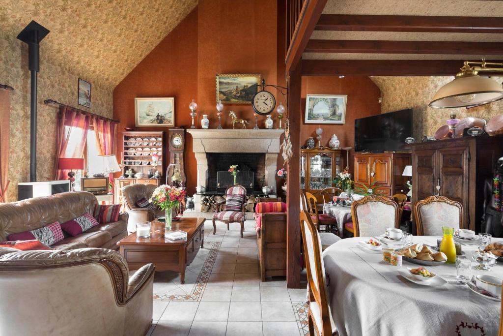 多尔德布列塔尼玛丽和吉恩弗朗索瓦住宿加早餐旅馆的客厅配有桌椅和壁炉