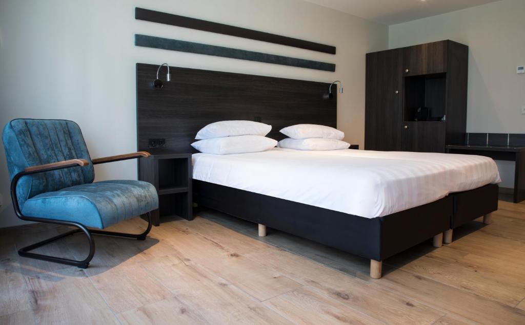 奥斯德纳尔德霍夫酒店的一间卧室配有一张大床和一张蓝色椅子