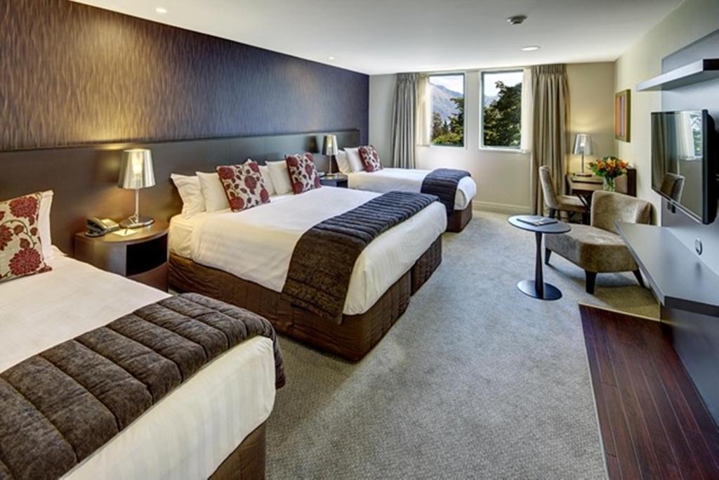 皇后镇Rendezvous Heritage Hotel Queenstown的有两张床和一台电视的酒店房间